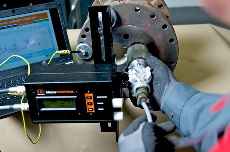 Techniker führt eine Gehäuseverschleißmessung an einem Extruder mit digitalem Messgerät und Laptop-Analyse durch